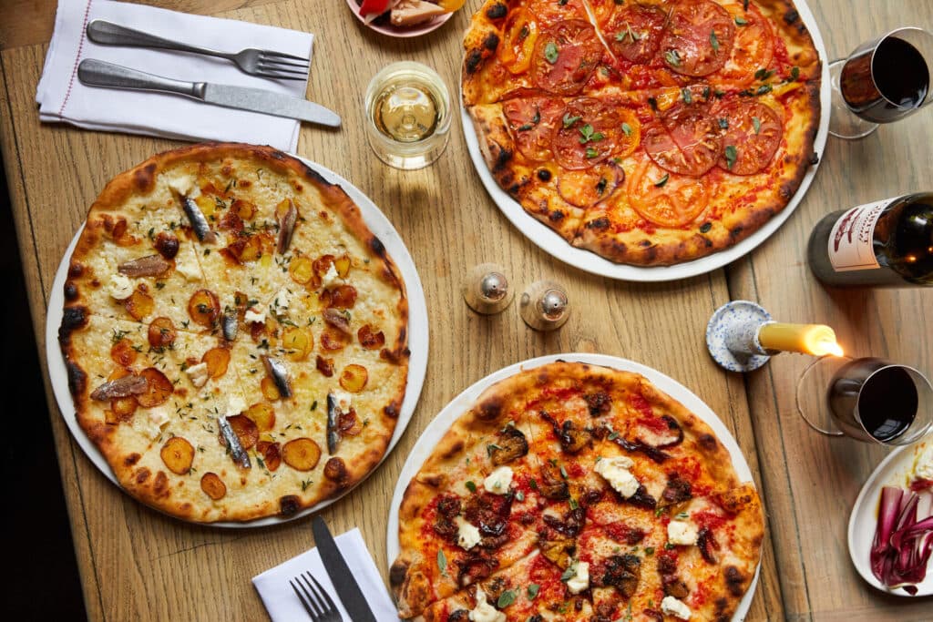 Artisan pizzas table spread at The Orange Pub & Boutique Hotel Belgravia, London