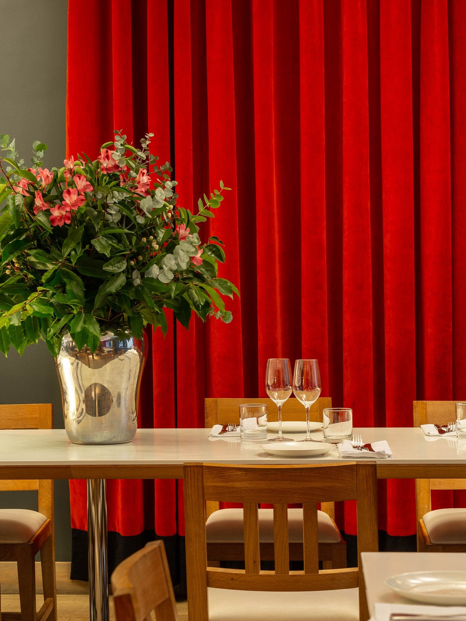 Elegant table setting with red curtain backdrop at Ottolenghi Hampstead, London