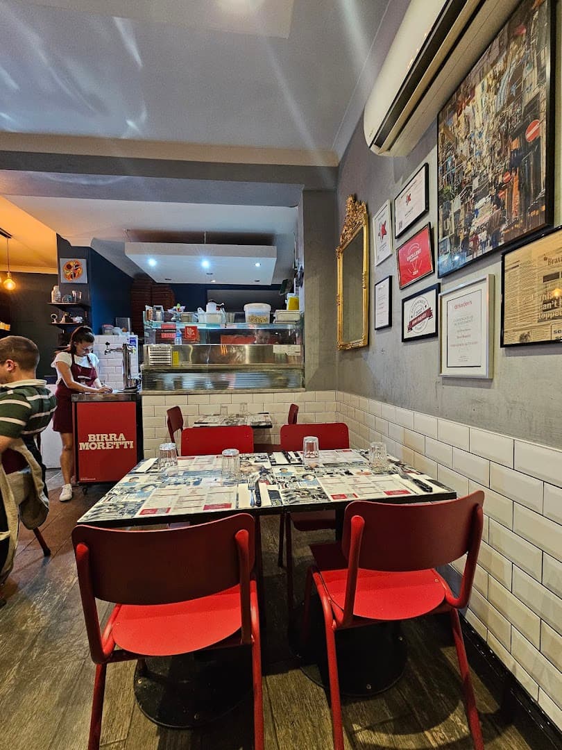 Cosy dining area with red banquette seating at Bravi Ragazzi, London