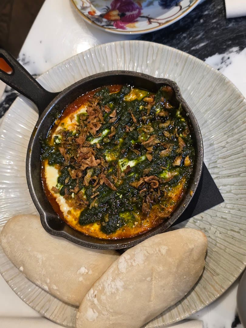 Baked egg dish in cast iron skillet at Queens of Mayfair, London