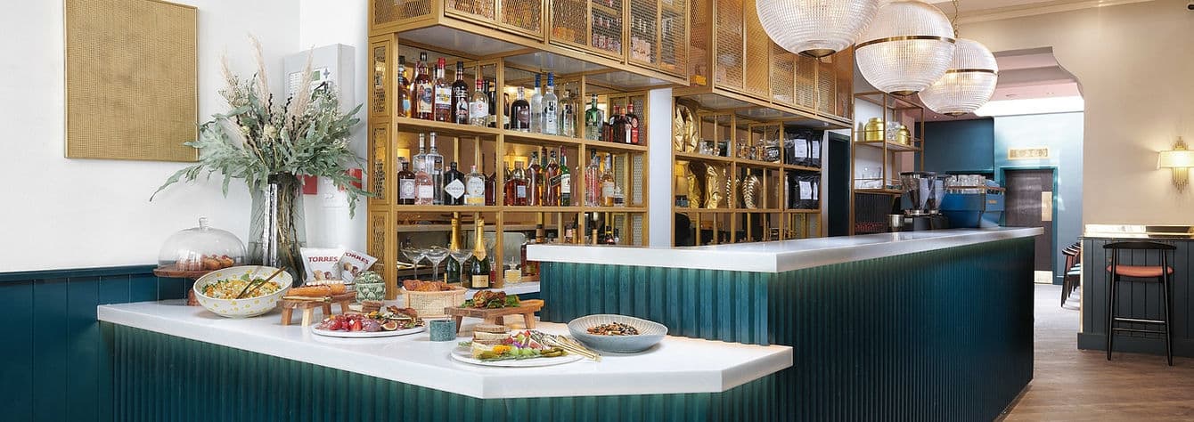 Bar area with buffet display at Queens of Mayfair, London