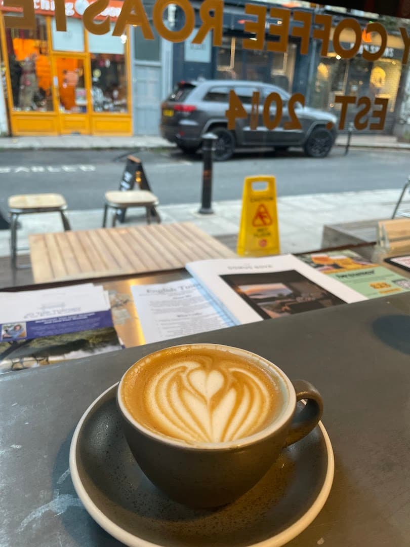 Latte with heart-shaped art at window seating at Tamp Coffee, London