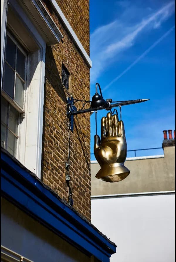 Front facade with distinctive golden hand sign at The Blue Stoops, London