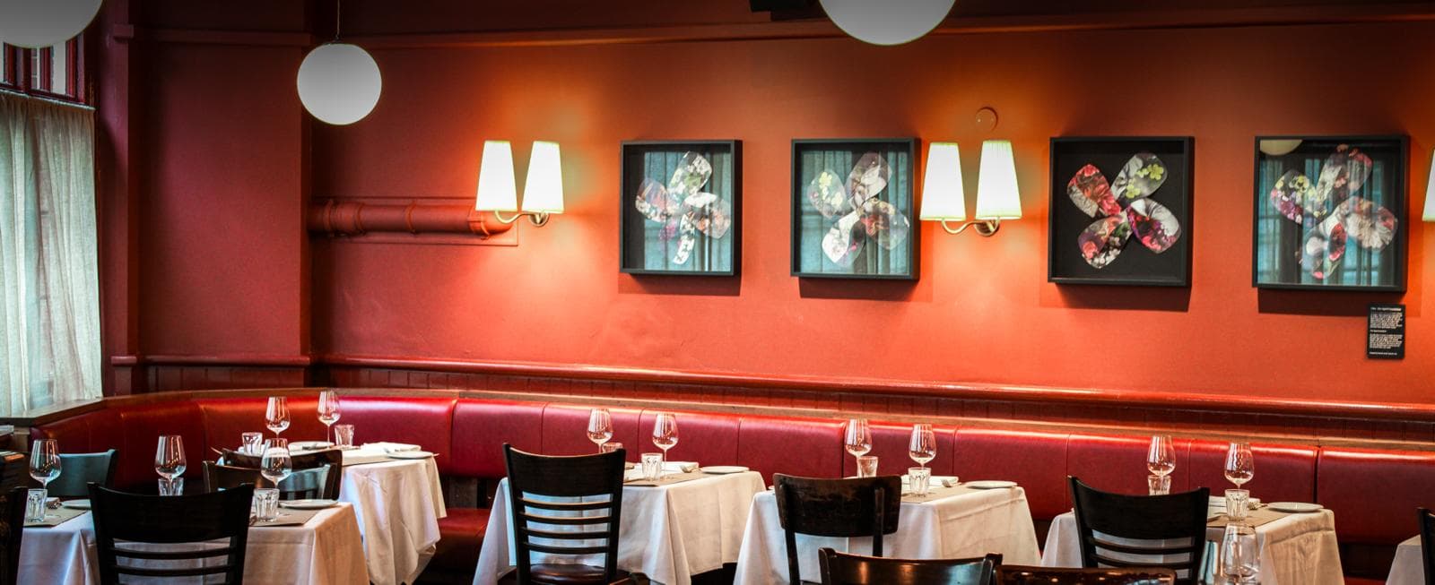 Elegant dining room with red banquette seating at The Devonshire, London
