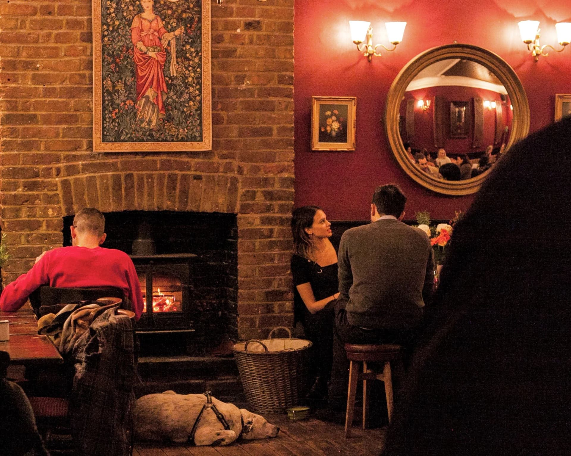 Cosy fireplace seating area with dog at Chesham Arms, London