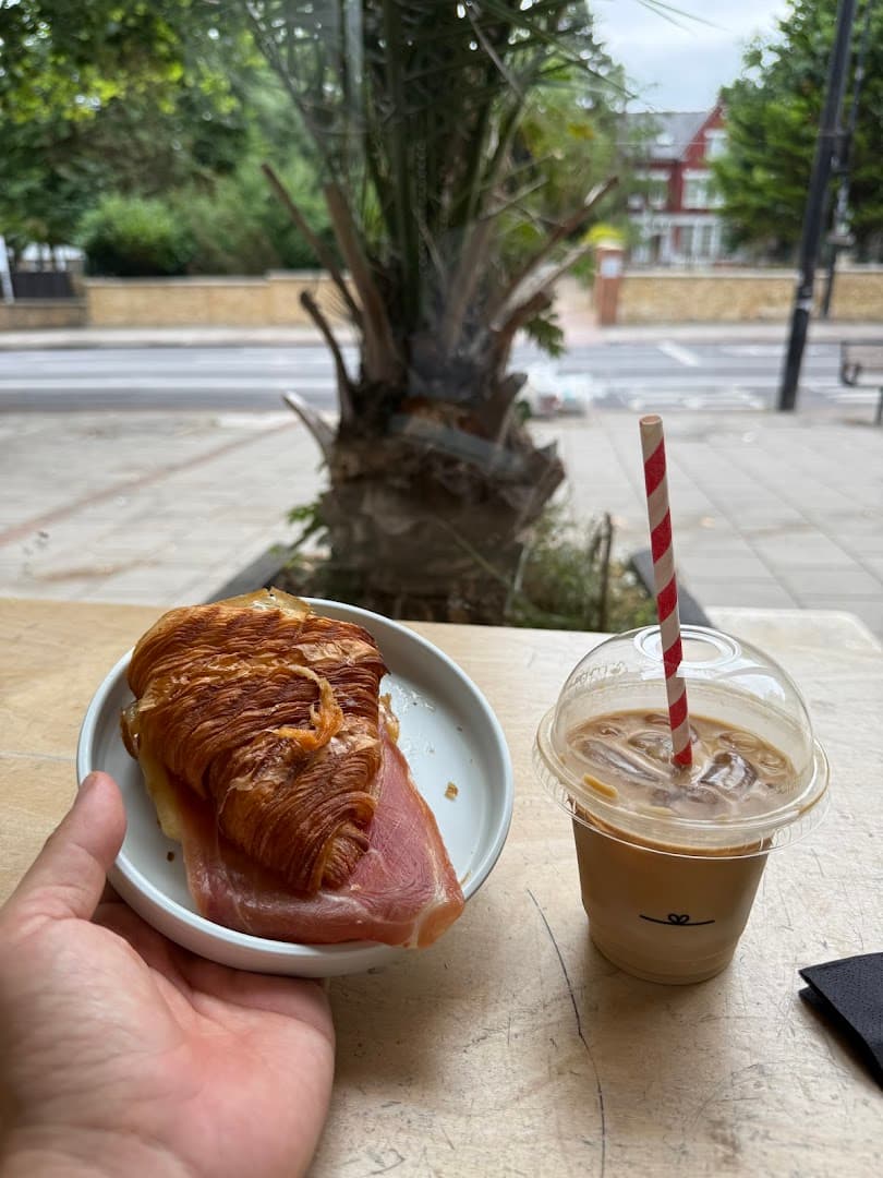 Outdoor seating with croissant and iced coffee at F. Mondays, London