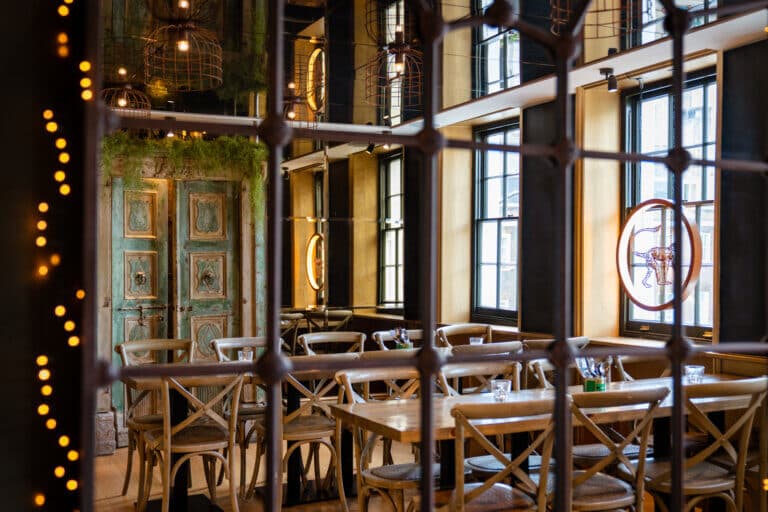 Dining room with rustic seating and vintage doors at Mowgli Street Food Charlotte Street, London