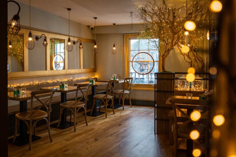 Warm dining room with festive lighting at Mowgli Street Food Charlotte Street, London