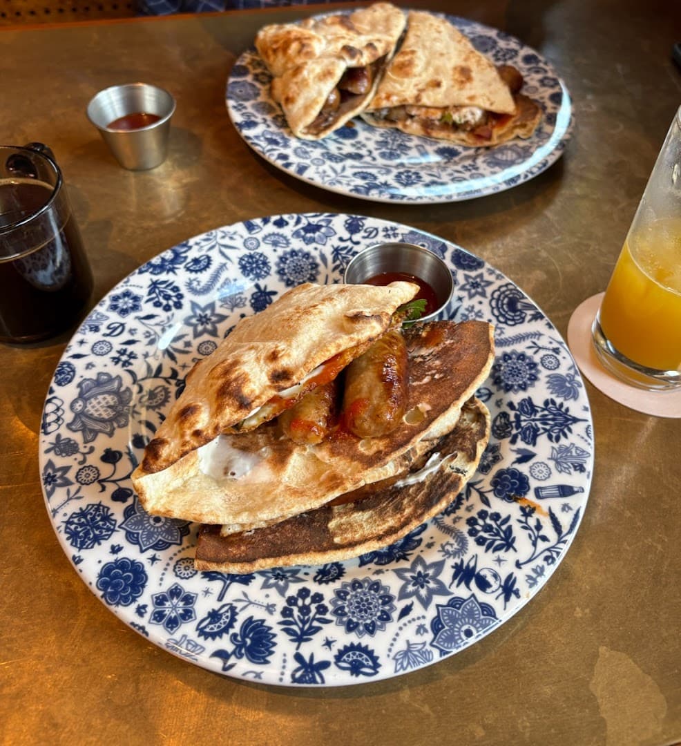 Breakfast quesadilla and sausage plate at Dishoom Permit Room Portobello, London