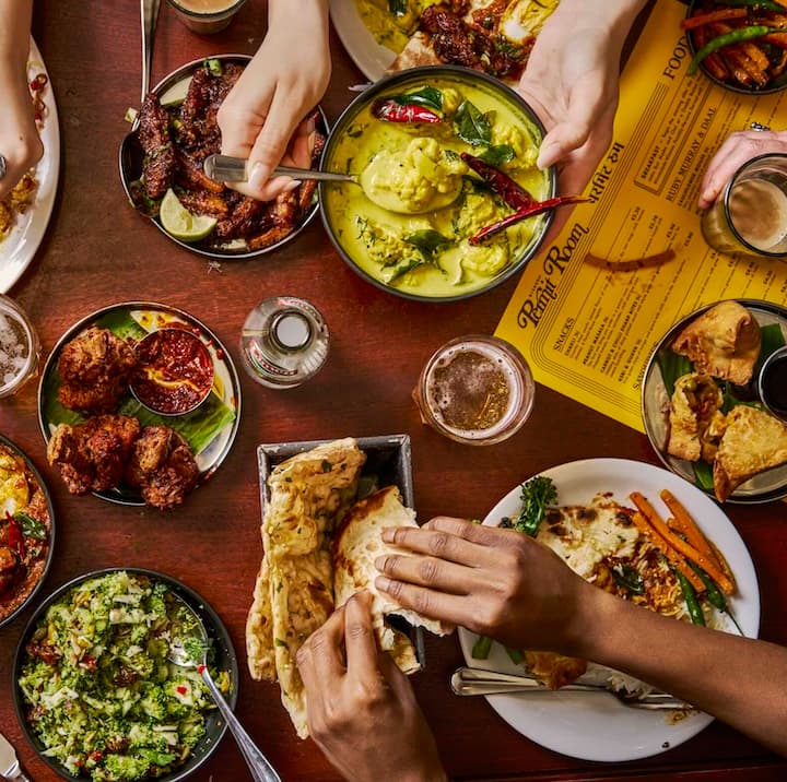 Shared feast spread at Dishoom Permit Room Portobello, London