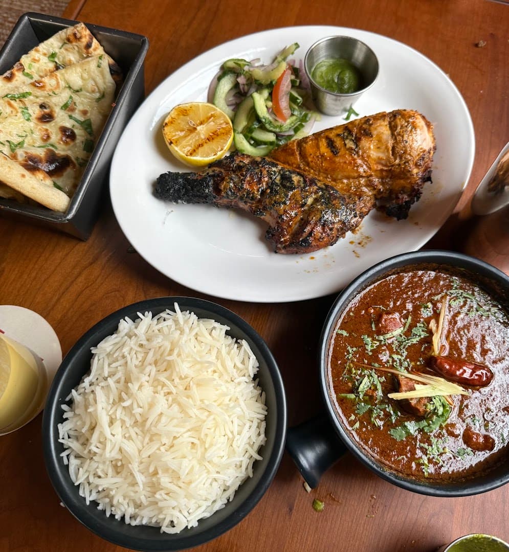 Tandoori chicken with curry, rice, and naan bread at Dishoom Permit Room Portobello, London