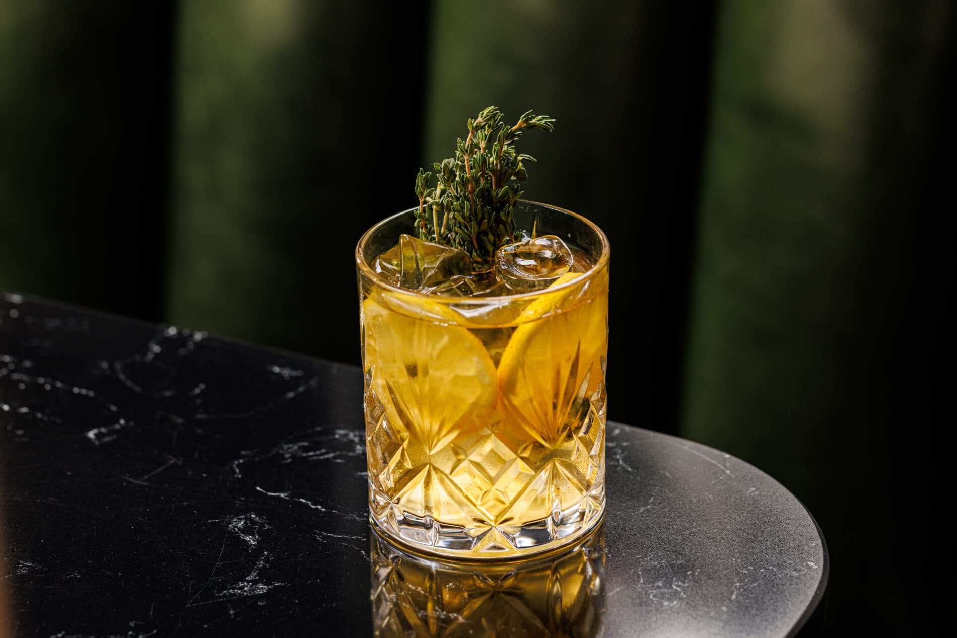 Craft cocktail with thyme garnish at The Hunter's Moon, London