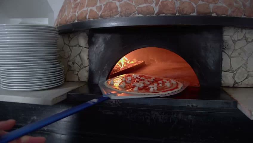 Pizza cooking in wood-fired oven at La Rosetta N16, London