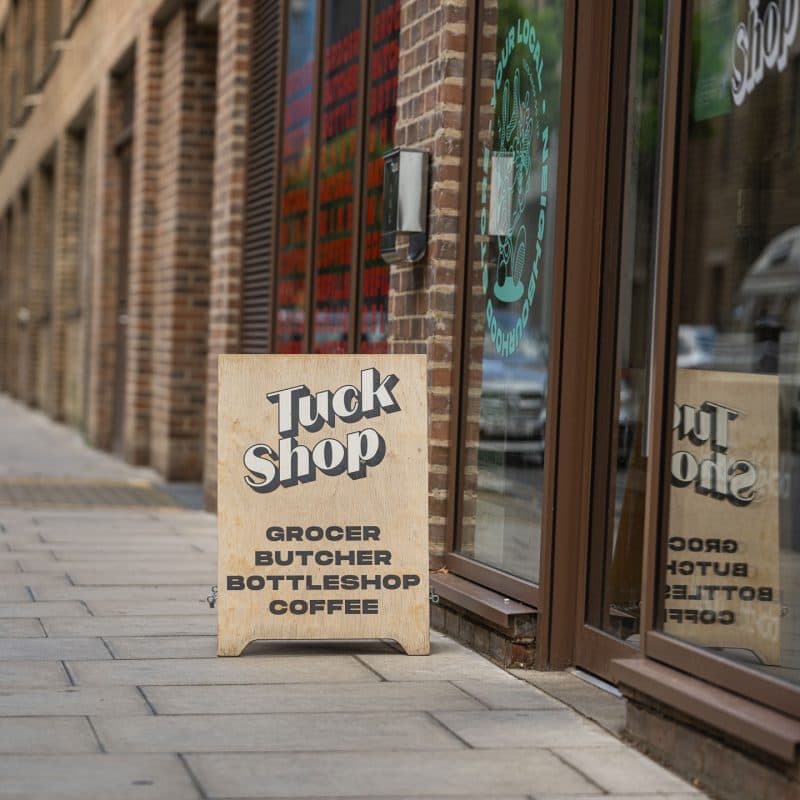 Storefront pavement sign at Tuck Shop, London