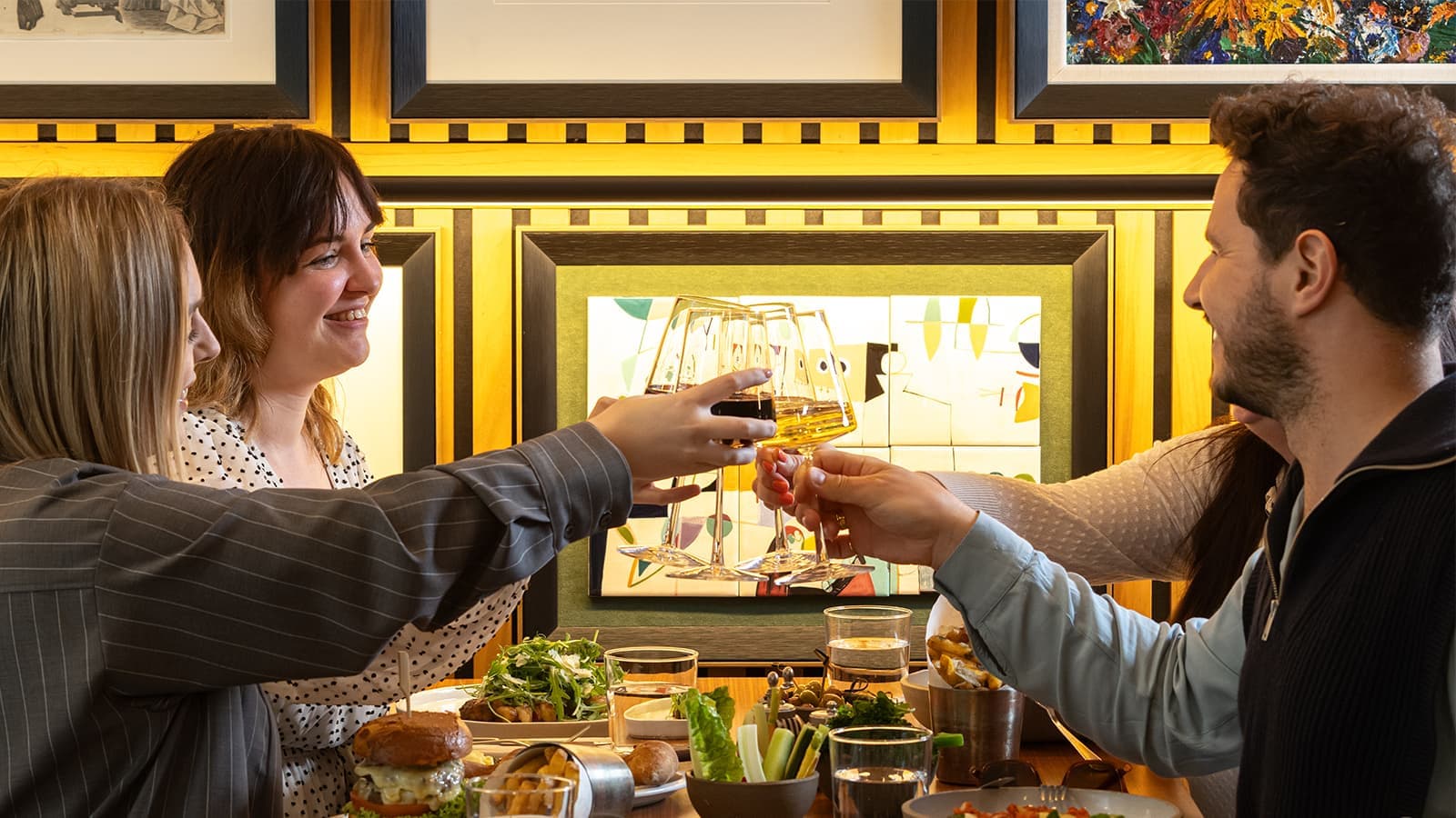 Diners toasting in cosy booth at Art Yard Bar & Kitchen, London