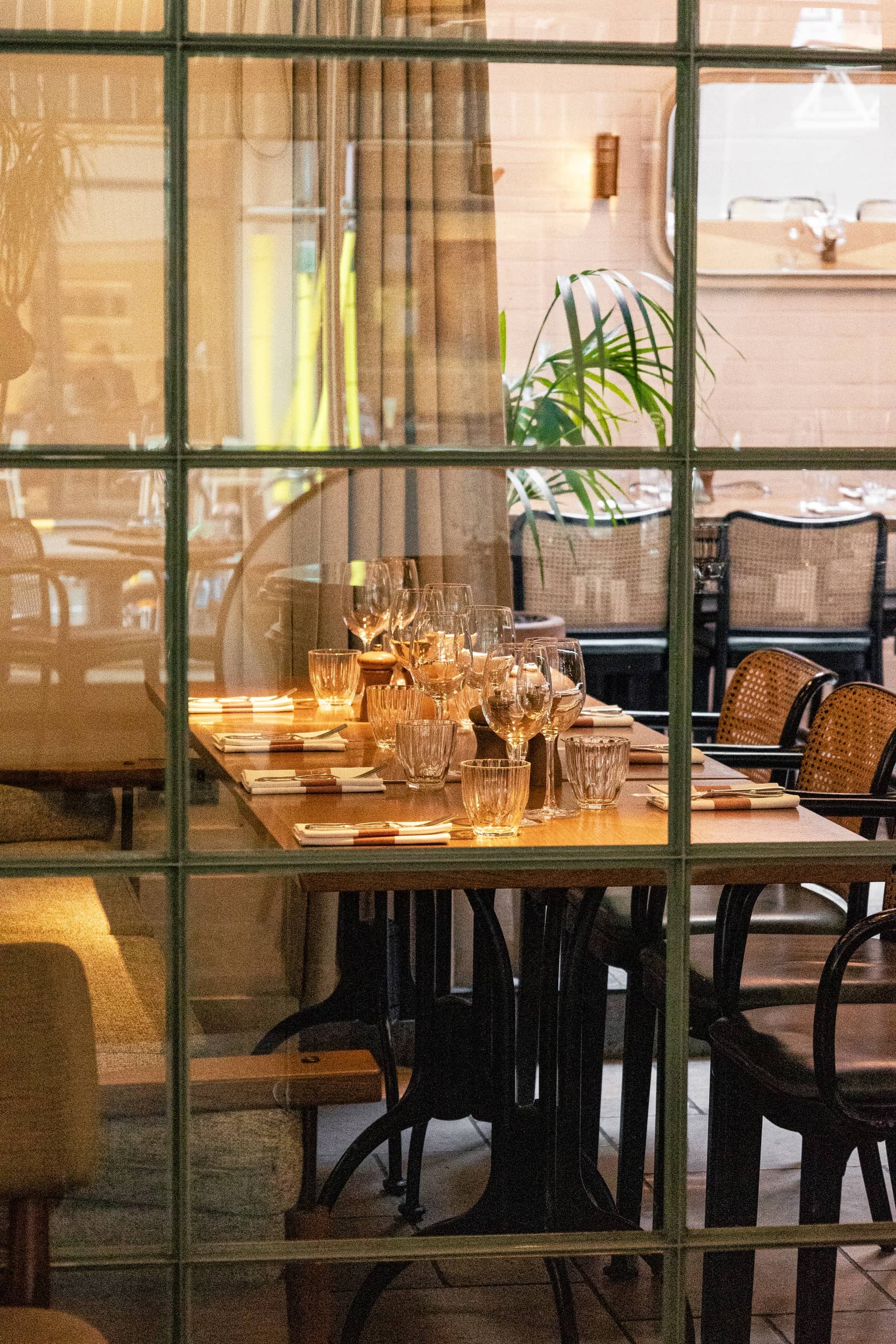 Table setting through glass partition at Mortimer House Kitchen, London