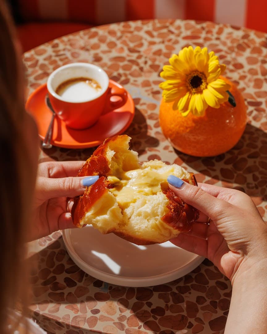 Torn doughnut with coffee at Bombolone Doughnuts, London