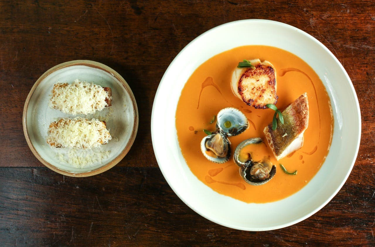 Seafood bisque with seared scallop and clams at Cora Pearl, London