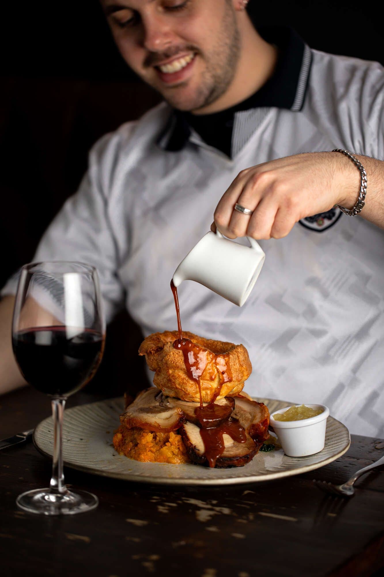 Roast dinner with Yorkshire pudding and gravy pour at Duke of Clarence, London