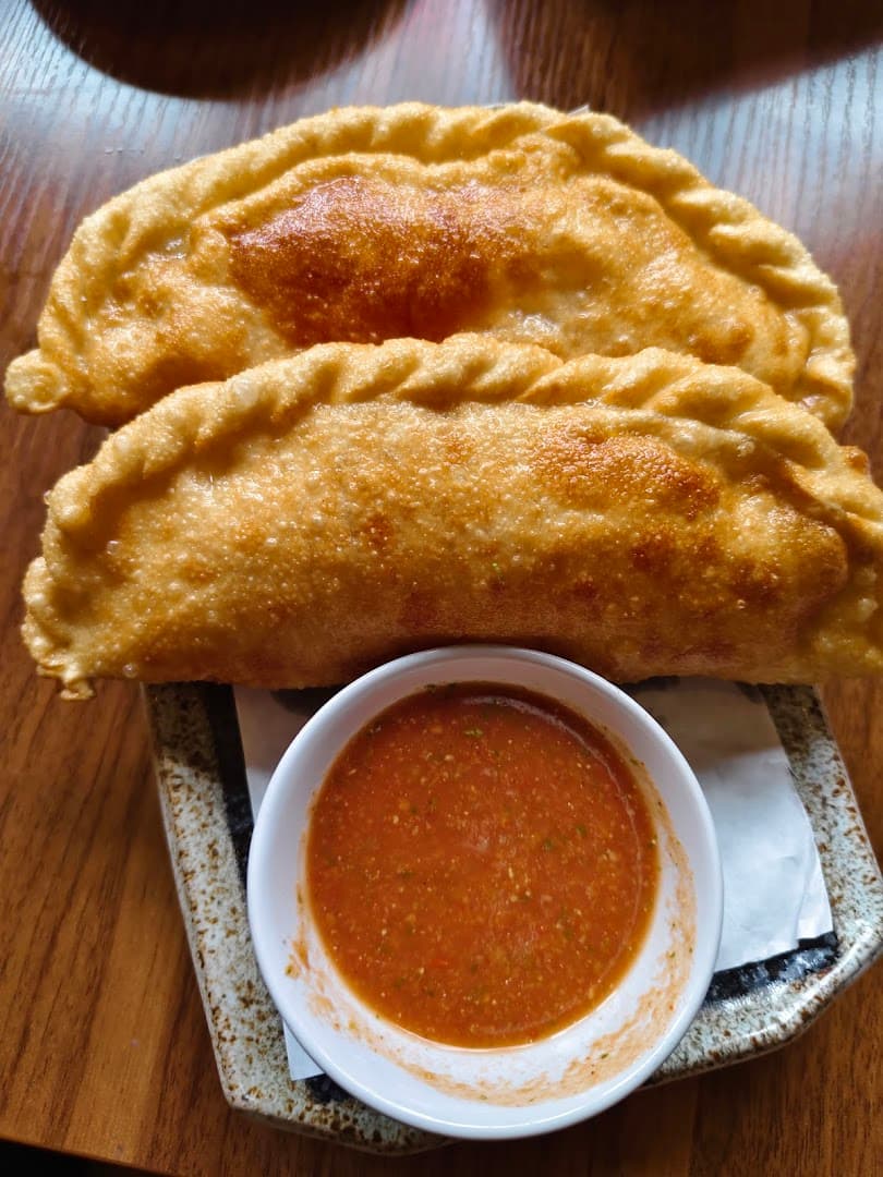 Fried samosas with dipping sauce at Rewa Sushi And Momo, London
