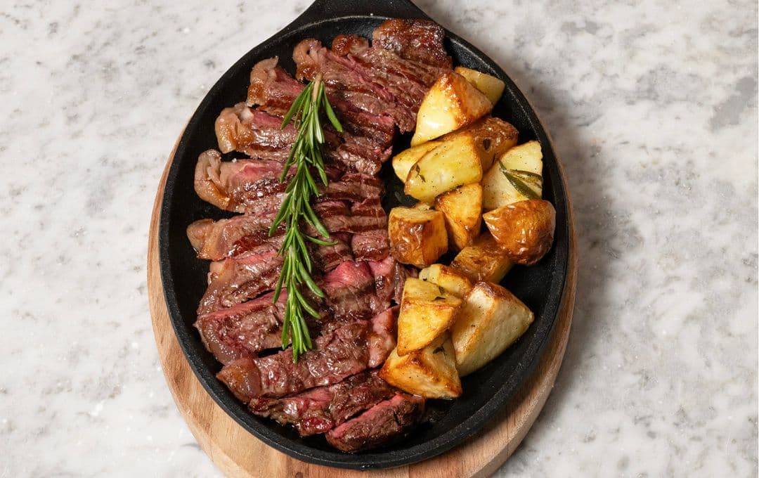 Sliced steak with roasted potatoes at Osteria Fiorentina, London