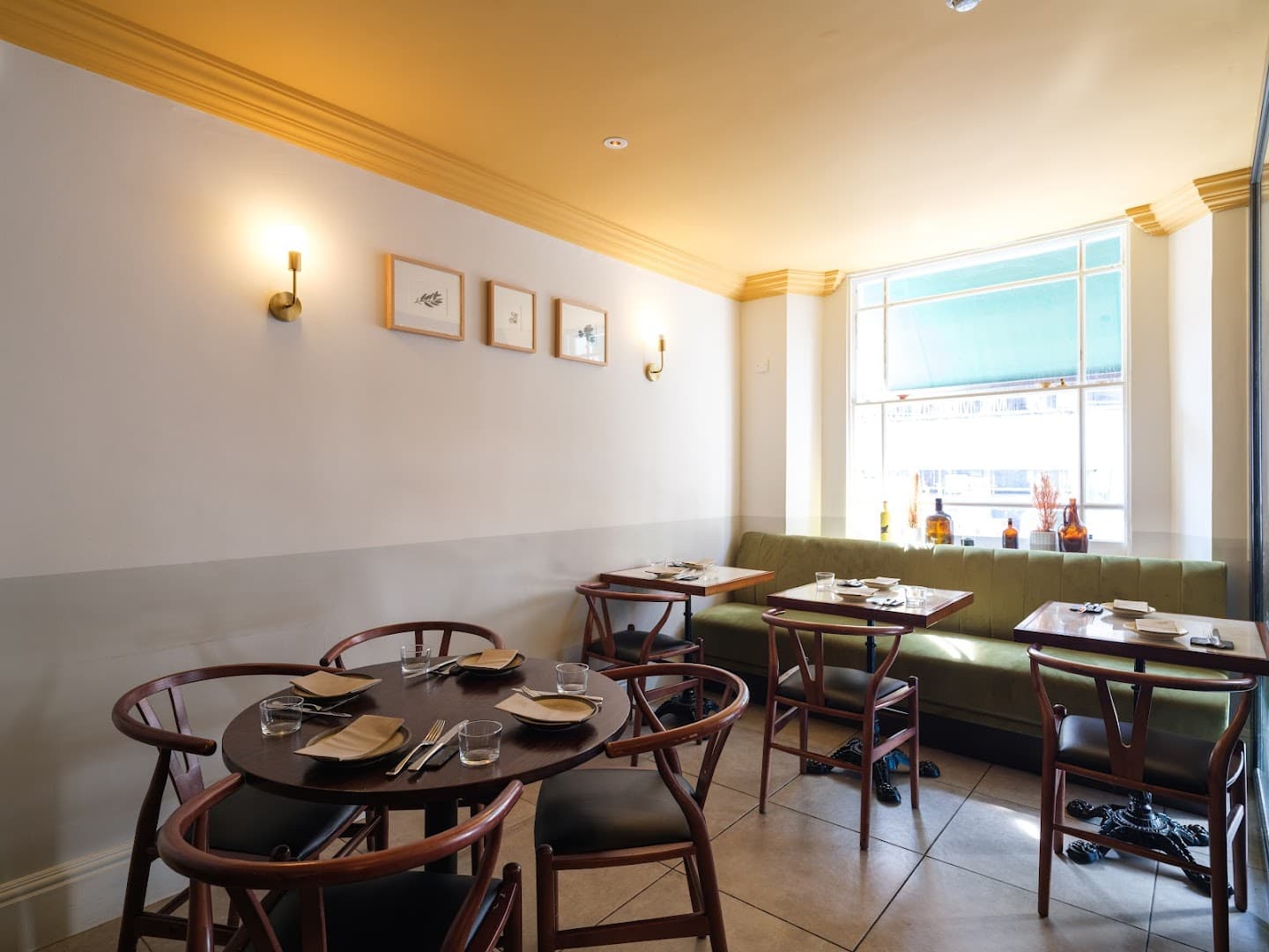 Bright dining room with green banquette seating at Tendril - A (mostly) Vegan Kitchen & Bar, London