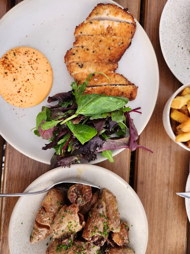 Breaded chicken schnitzel with salad at Milk Beach Soho, London