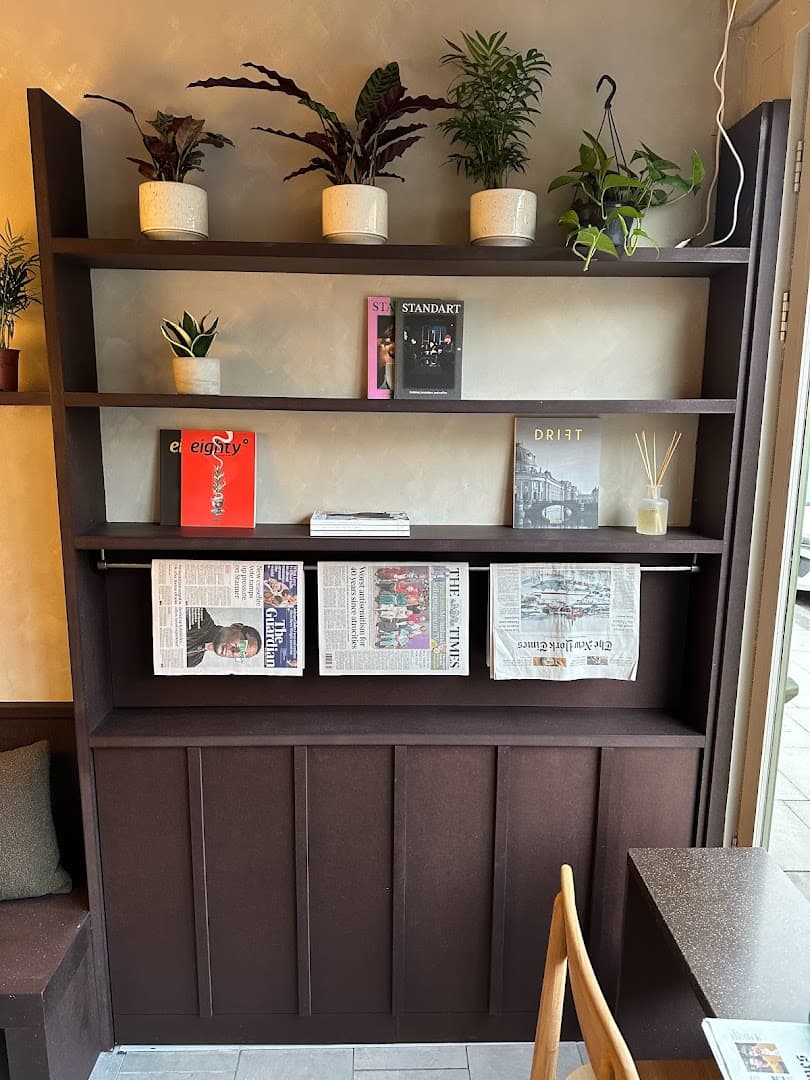 Bookshelf display with plants at Moonstruck Cafe, London