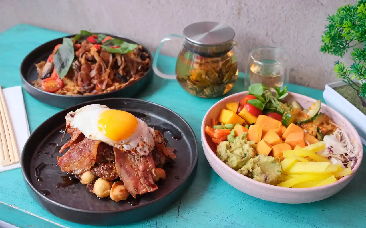 Noodles with egg and bacon alongside colourful buddha bowl at Tampopo Fitzrovia, London