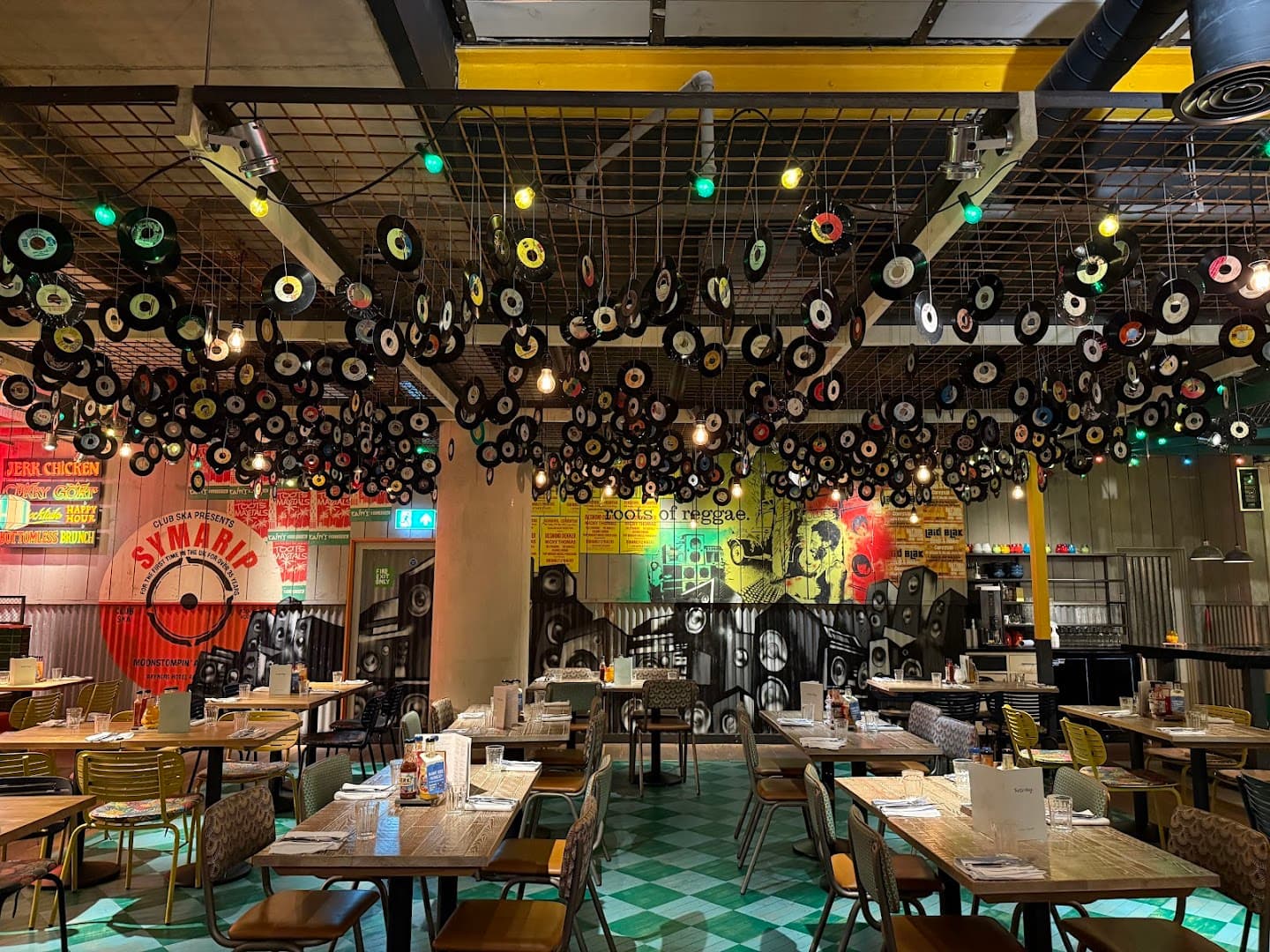 Caribbean-themed dining room with vinyl record ceiling installation at Turtle Bay Hammersmith, London