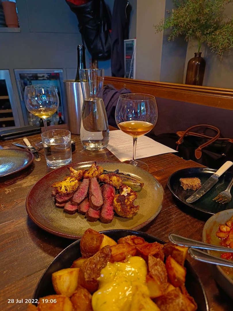 Sliced steak with roast potatoes platter at Vins, London